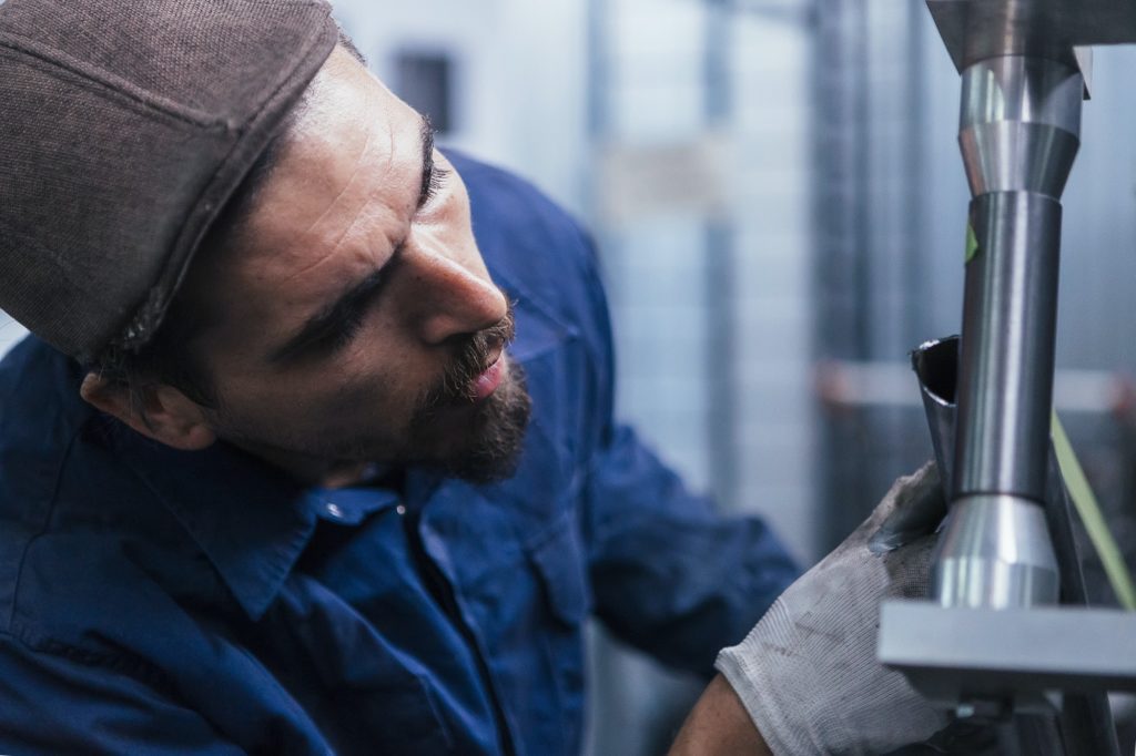 Close-up of bearded worker constructing bike